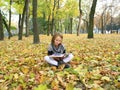 Young girl reads a book in the autumn park Royalty Free Stock Photo