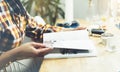 Young girl reads book during breakfast and coffee, female hands close up flipping through magazine pages in home relax atmosphere