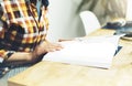 Young girl reads book during breakfast and coffee, female hands close up flipping through magazine pages in home relax atmosphere