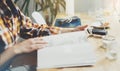 Young girl reads book during breakfast and coffee, female hands close up flipping through magazine pages in home relax atmosphere