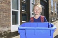 Young girl with recycle bin outside