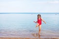 young girl in a red bathing suit and glasses playing on the beach Royalty Free Stock Photo