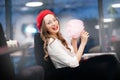 Young girl in red beret and glasses eats pink candy floss in France cafe Royalty Free Stock Photo