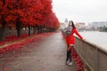 Young girl in a red coat stands on the alley of the park Royalty Free Stock Photo