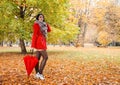 Young girl in a red coat with an umbrella standing on the alley Royalty Free Stock Photo