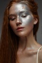 A young girl with red hair and a brilliant silver make-up with the stars. Beautiful model with shining skin. Holiday image. Royalty Free Stock Photo