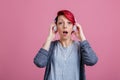 A young girl with with headphones, with a surprised look, opening her mouth. Royalty Free Stock Photo