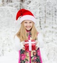 Young girl with red hat holds out a gift Royalty Free Stock Photo