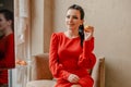 Young girl in a red indoors. Pensive model. Emotions of a modern lady. Girl eating an apple Royalty Free Stock Photo