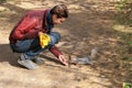 A young girl in a red jacket feeds a squirrel from her hands on nature on a good autumn day