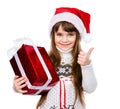 Young girl with red santa hat holding gift box and showing thumbs up. isolated on white background Royalty Free Stock Photo