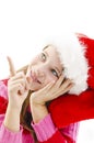 Young girl in red Santa hat, looking up and pointing copy space Royalty Free Stock Photo