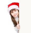 Young girl in red santa hat standing behind white board and showing thumbs up. on white Royalty Free Stock Photo