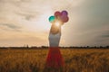 Girl with balloons in wheat field and sunshine on the sunset Royalty Free Stock Photo