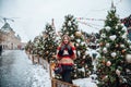 Young russian girl on the red Square through winter holiday in Moscow, stylish and beautiful posing near to Christmas tree Royalty Free Stock Photo