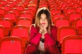 Young girl in a red suit sits on the podium of the stadium. Royalty Free Stock Photo