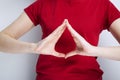 Young girl in red T-shirt shows her hands drop on grey background. Blood donorship symbol