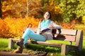 Young girl relaxing in autumnal park reading book Royalty Free Stock Photo