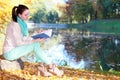 Young girl relaxing in autumnal park reading book Royalty Free Stock Photo