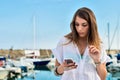 Young girl relaxing while earing music at the dock