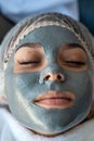 Young girl relaxing at spa, lying in bed with facial mask Royalty Free Stock Photo