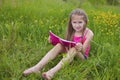 A young girl is reluctant to perform school homework in nature