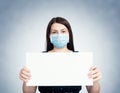 Young girl in respiratory mask holding blank white banner.