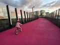 Young girl ride a bike on bright pink cycleway in Auckland New