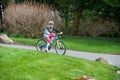 A young girl rides a bike along a country road wearing a cycle helmet Royalty Free Stock Photo