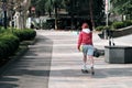 A young girl rides a skateboard along a beautiful street in the city