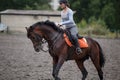 Young girl riding bay horse on equestrian sport training Royalty Free Stock Photo