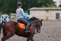 Young girl riding bay horse on equestrian sport training Royalty Free Stock Photo