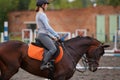 Young girl riding bay horse on equestrian sport training Royalty Free Stock Photo