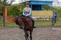 Young girl riding bay horse on equestrian sport training Royalty Free Stock Photo