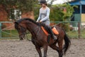 Young girl riding bay horse on equestrian sport training Royalty Free Stock Photo