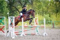 Young girl riding bay horse on show jumping Royalty Free Stock Photo