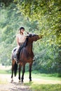 Young girl riding horseback at early morning in sunbeam Royalty Free Stock Photo