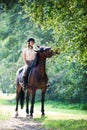 Young girl riding horseback at early morning in sunbeam Royalty Free Stock Photo