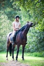 Young girl riding horseback at early morning in sunbeam Royalty Free Stock Photo