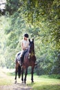 Young girl riding horseback at early morning in sunlight Royalty Free Stock Photo