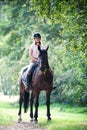 Young girl riding horseback at early morning in sunlight Royalty Free Stock Photo