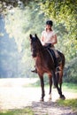 Young girl riding horseback at early morning in sunlight Royalty Free Stock Photo