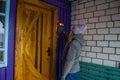 Young girl rings the door of the house in the winter. Background.