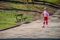 A young girl on roller blades passes a park bench Royalty Free Stock Photo