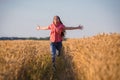 Young girl running on field with ripe wheat Royalty Free Stock Photo