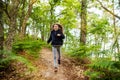 young girl running and leaping in the paths of a beautiful forest Royalty Free Stock Photo