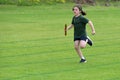 Young girl running relay race on grass running track outdoors Royalty Free Stock Photo