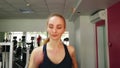 Young girl running on the treadmill in the sport gym.