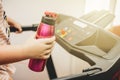 Young girl running on the treadmill with a sports water bottle in hand Royalty Free Stock Photo