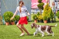 Young girl runs presenting a dog.